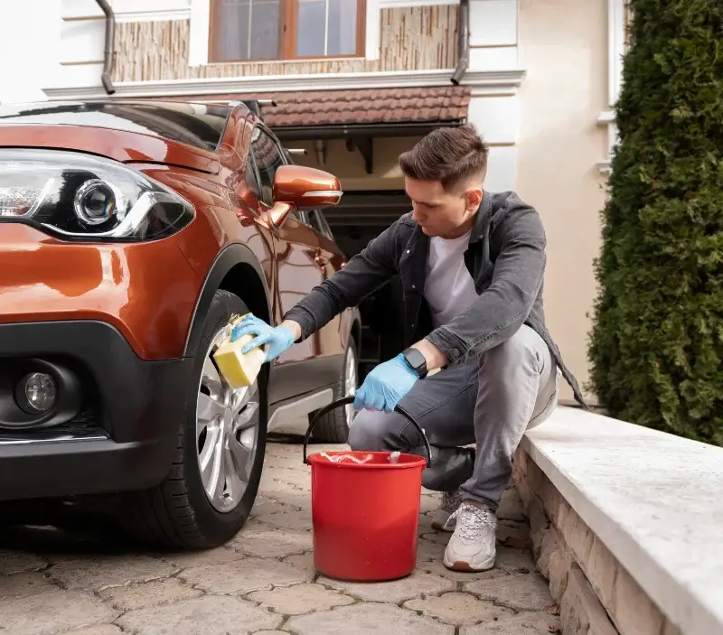 Lavage auto à domicile La Chaux : professionnel intervenant sur un véhicule